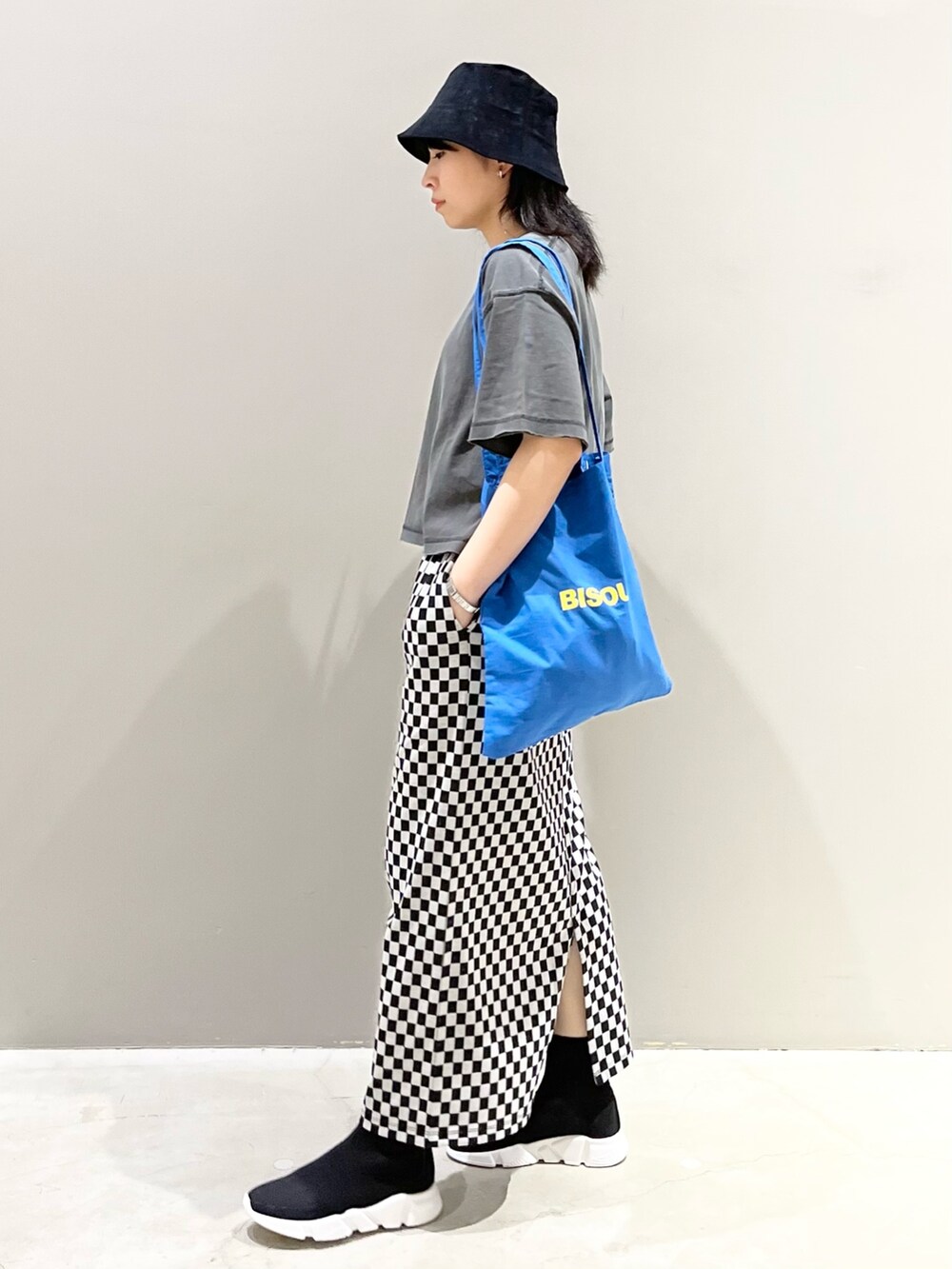 ブルー系のトートバッグ、ブラック系のシューズ、グレー系のTシャツ/カットソーを着用したレディースの秋コーディネートの3枚目の写真