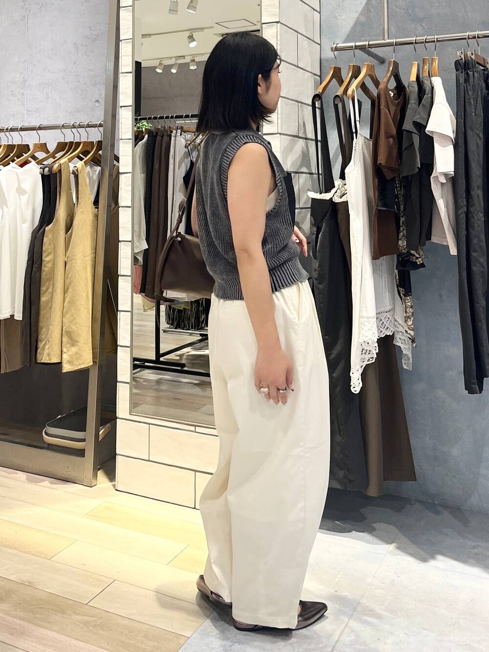 ブラウン系のショルダーバッグ、ホワイト系のタンクトップ、シルバー系のキーホルダーを着用したレディースの夏コーディネートの5枚目の写真