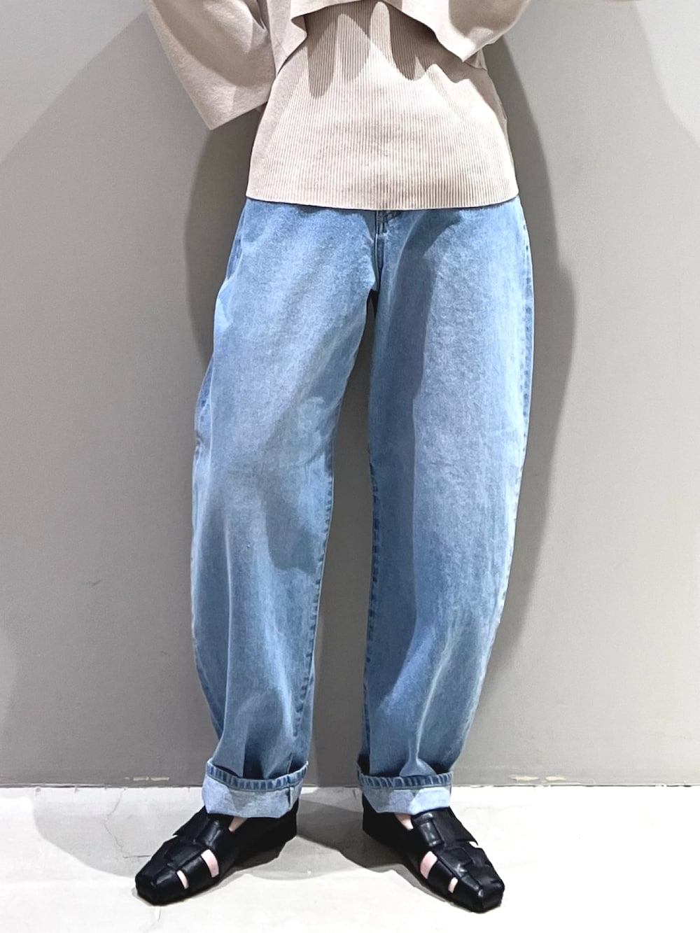 ブルー系のデニムパンツ、ブラック系のシューズ、ベージュ系のニット/セーターを着用したレディースの春コーディネートの7枚目の写真