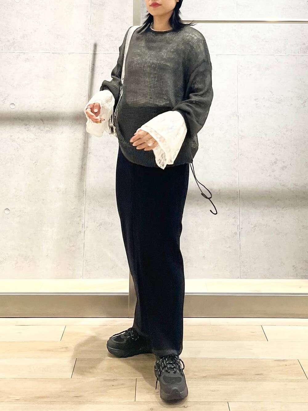 シルバー系のショルダーバッグ、ブラック系のスカート、ホワイト系のTシャツ/カットソーを着用したレディースの秋コーディネートの3枚目の写真