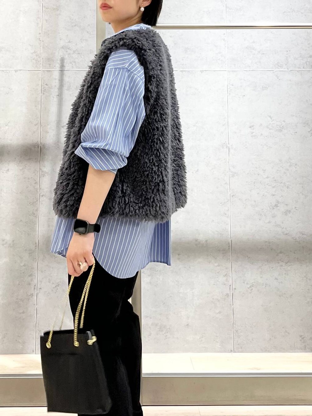 グレー系のベスト、ブラック系のその他パンツ、ブラック系のローファーを着用したレディースの秋コーディネートの7枚目の写真