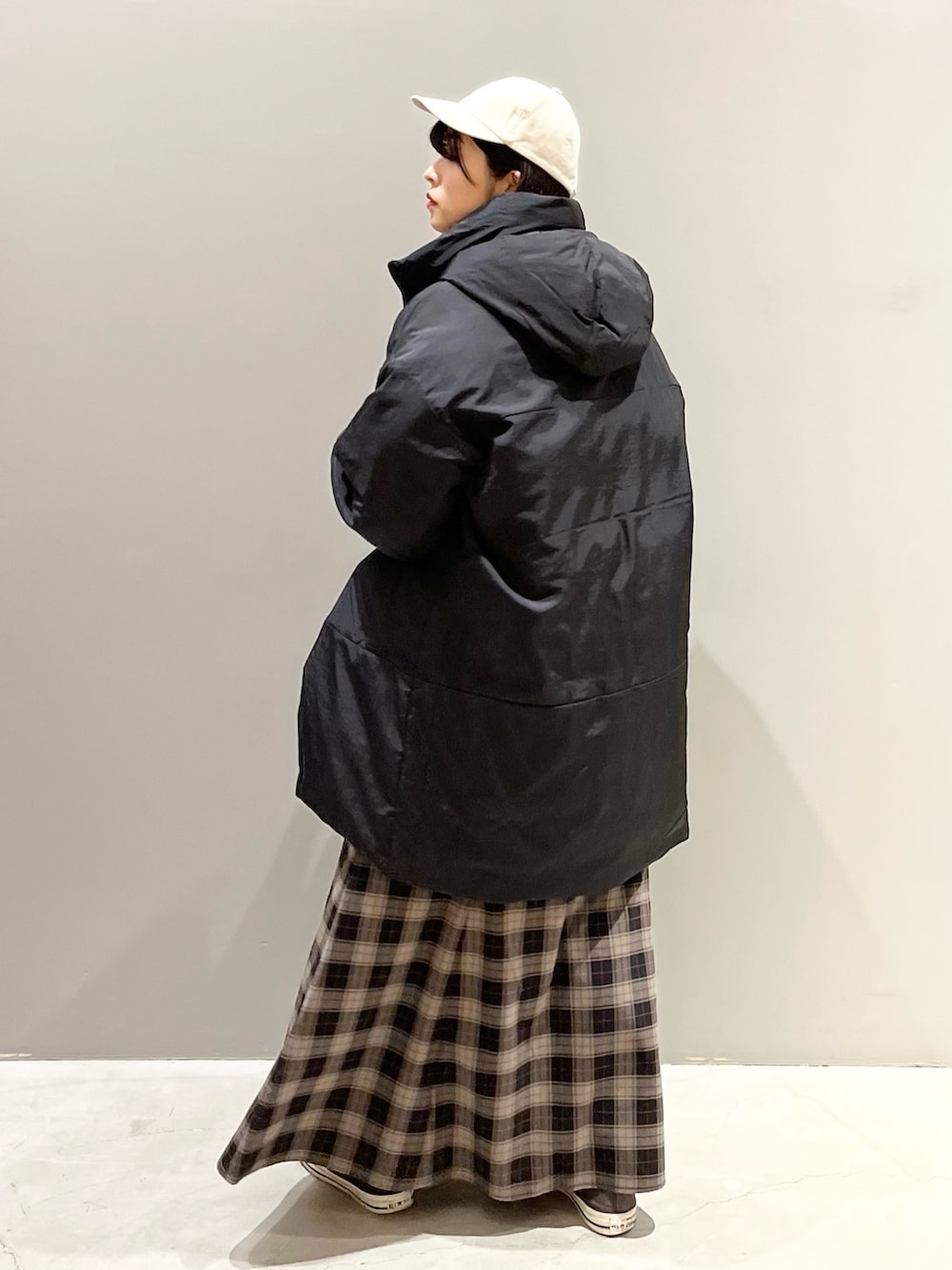 ブラック系のスカート、グレー系のスニーカー、ホワイト系のショルダーバッグを着用したレディースの冬コーディネートの2枚目の写真