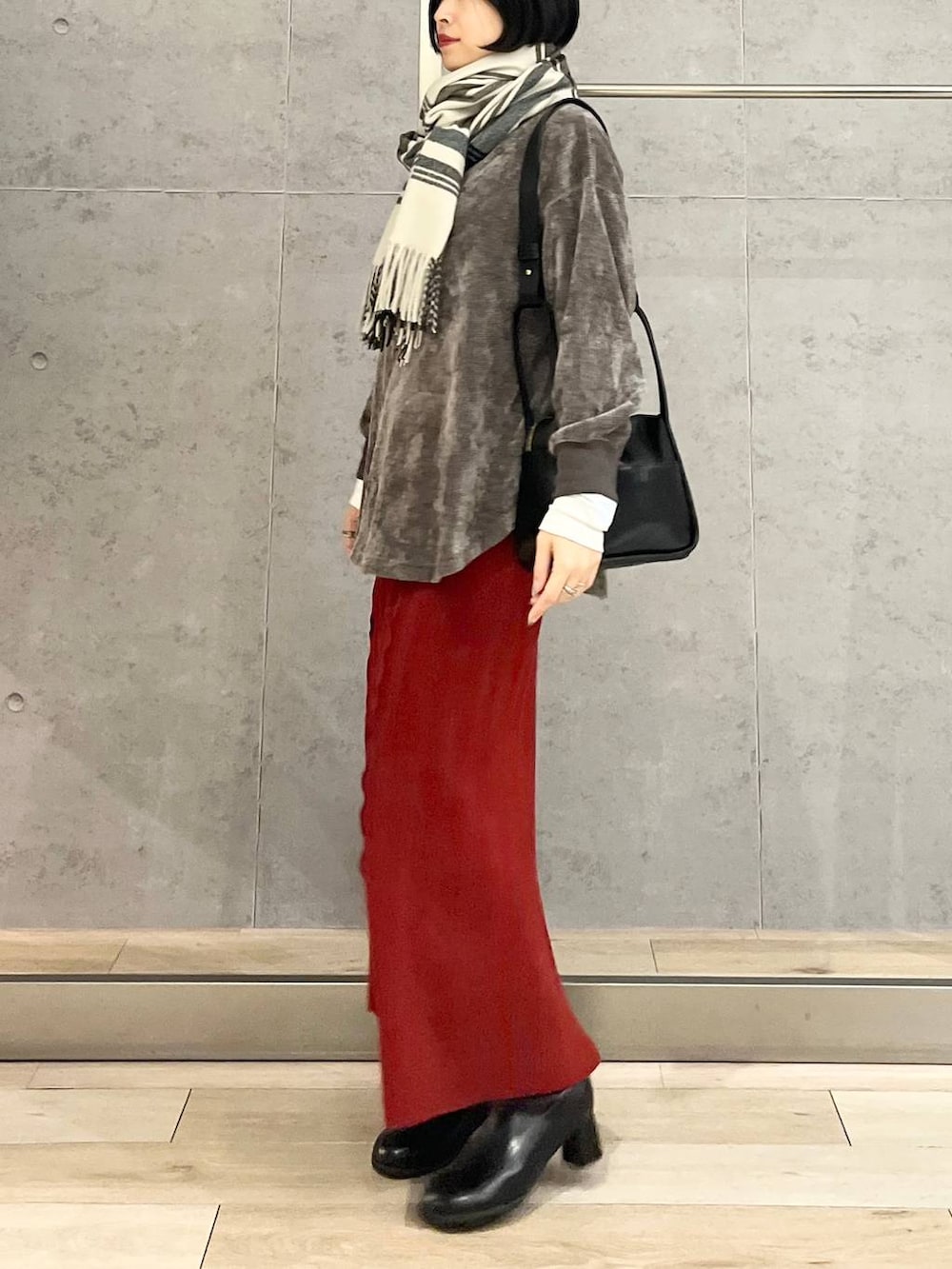 ブラック系のブーツ、ブラック系のショルダーバッグ、グレー系のTシャツ/カットソーを着用したレディースの冬コーディネートの2枚目の写真