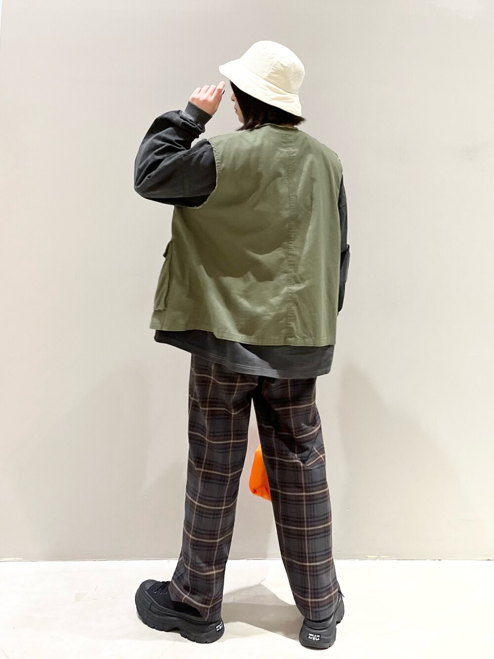 ブラウン系のスラックス、ブラック系のスニーカー、グリーン系のジャケット/アウターを着用したレディースの春コーディネートの4枚目の写真