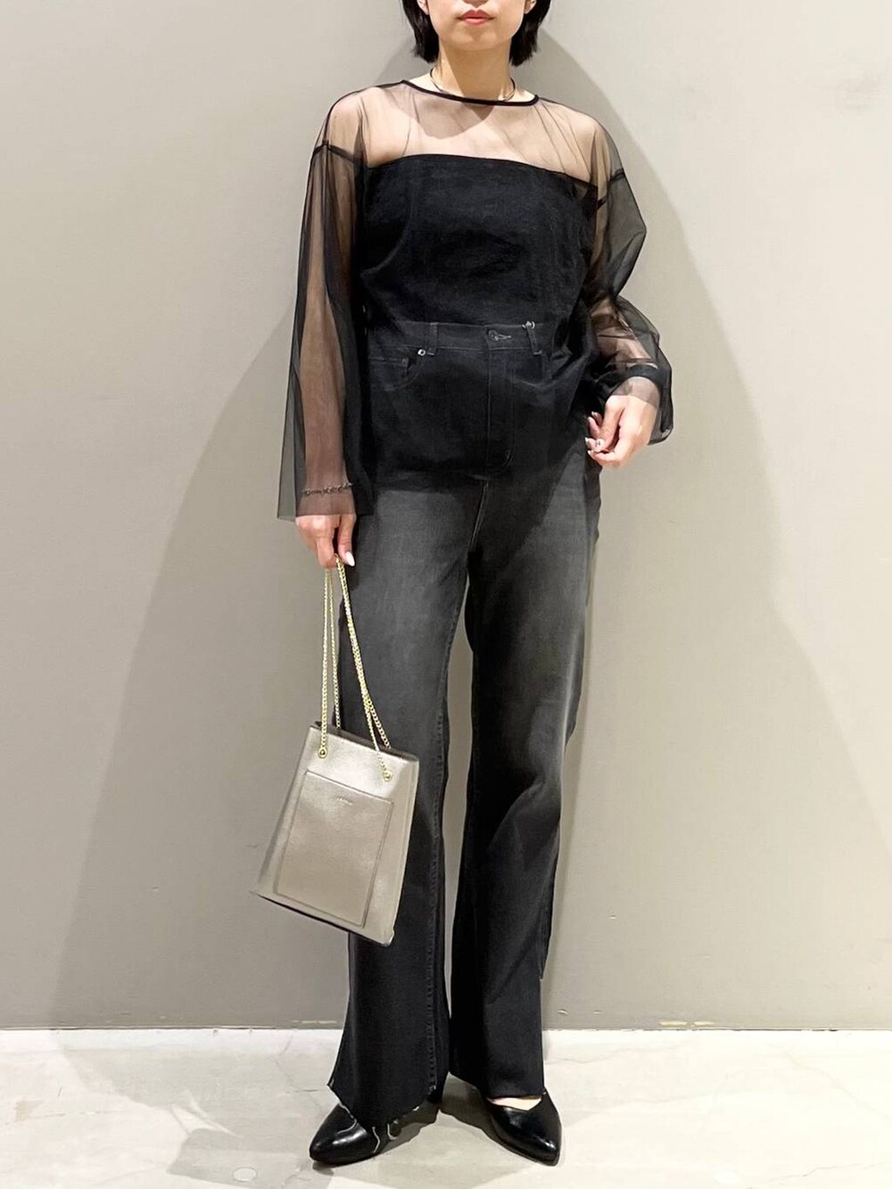 ブラック系のチューブトップ、ブラック系のTシャツ/カットソー、ブラック系のデニムパンツを着用したレディースの秋コーディネートの6枚目の写真