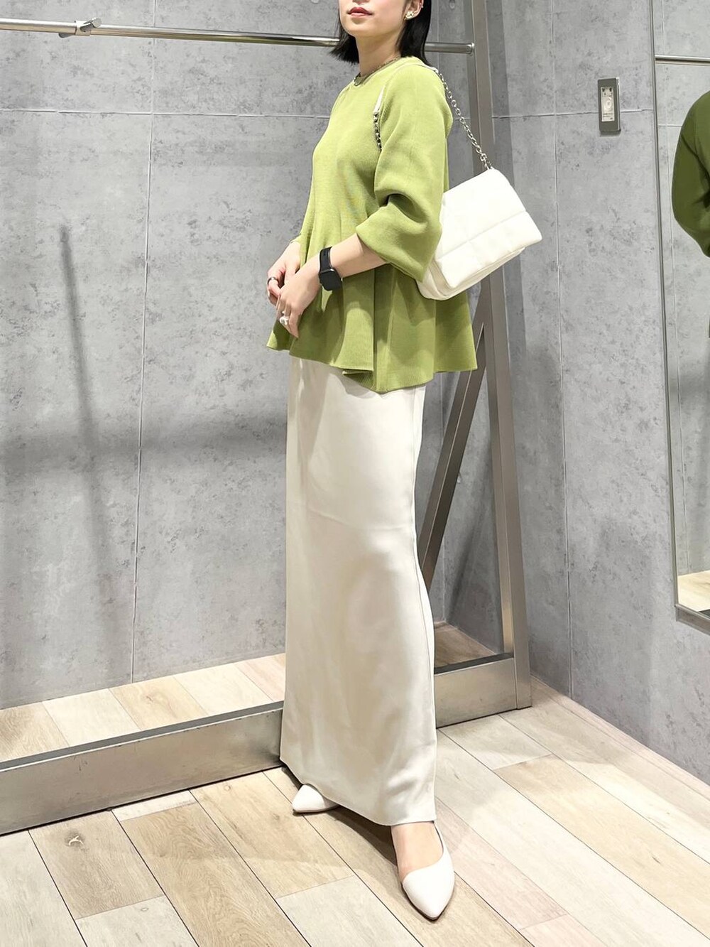 ホワイト系のショルダーバッグ、グリーン系のニット/セーター、ホワイト系のスカートを着用したレディースの春コーディネートの5枚目の写真