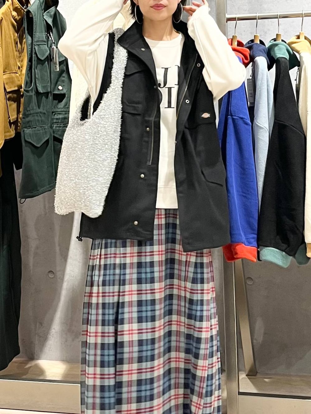 ブラック系のベスト、ホワイト系のスウェット、ブラック系のブーツを着用したレディースの秋コーディネートの4枚目の写真