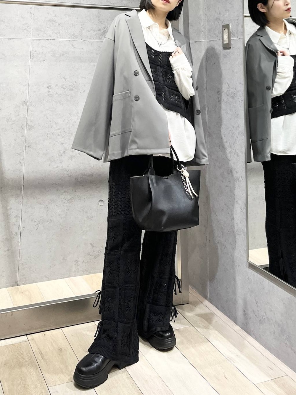 ブラック系のブーツ、ホワイト系のシャツ/ブラウス、グレー系のテーラードジャケットを着用したレディースの冬コーディネートの4枚目の写真