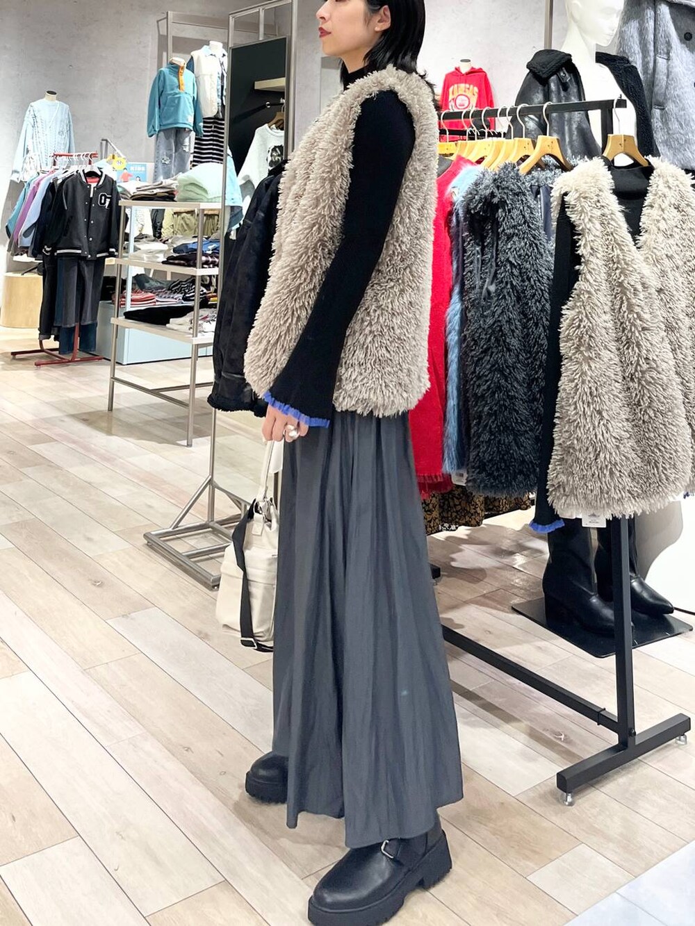 ホワイト系のショルダーバッグ、グレー系のその他パンツ、ブラック系のブーツを着用したレディースの秋コーディネートの3枚目の写真