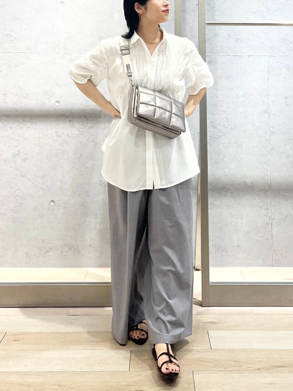 ブラック系のサンダル、ブラック系のハンドバッグ、グレー系のスラックスを着用したレディースの夏コーディネートの10枚目の写真