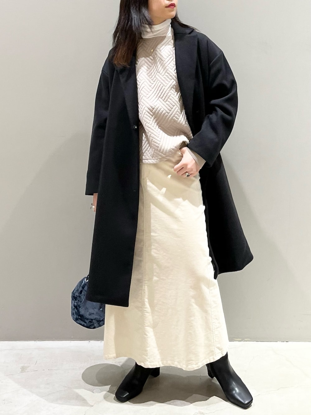 ベージュ系のTシャツ/カットソー、グリーン系のトップス、ブルー系のショルダーバッグを着用したレディースの冬コーディネートの2枚目の写真