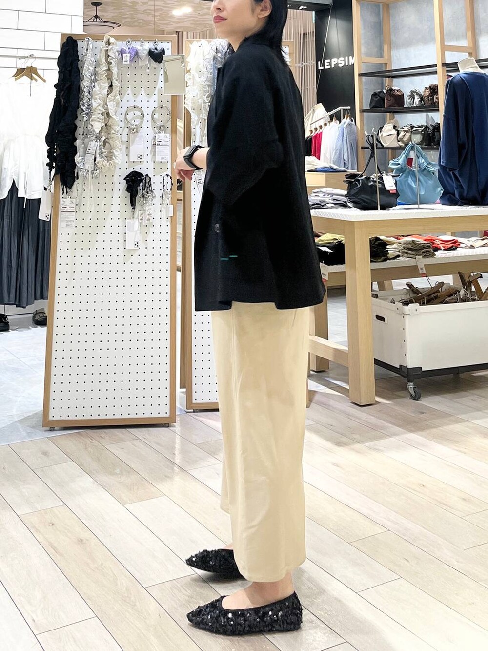 ブラック系のテーラードジャケット、ブラック系のショルダーバッグ、ホワイト系のTシャツ/カットソーを着用したレディースの夏コーディネートの3枚目の写真