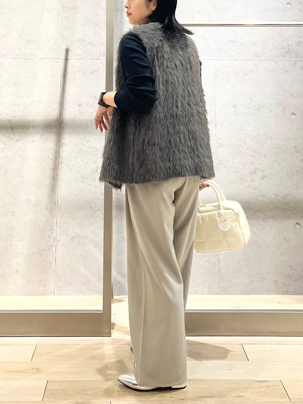 シルバー系のその他シューズ、ホワイト系のボストンバッグ、ブラック系のTシャツ/カットソーを着用したレディースの秋コーディネートの4枚目の写真