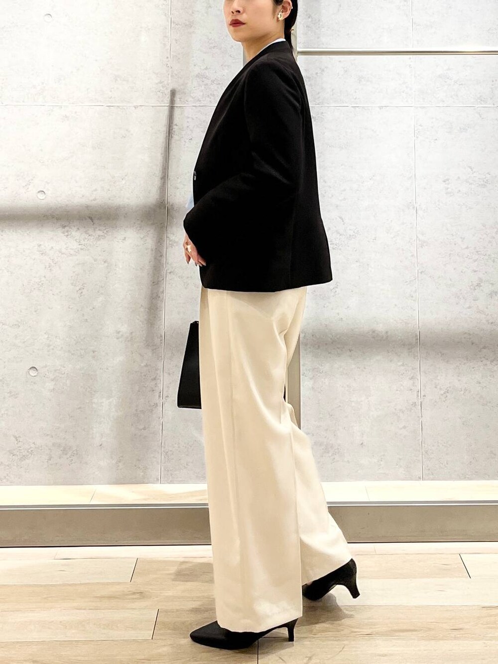 ブルー系のシャツ/ブラウス、ブラック系のノーカラージャケット、ブラック系のショルダーバッグを着用したレディースの冬コーディネートの7枚目の写真