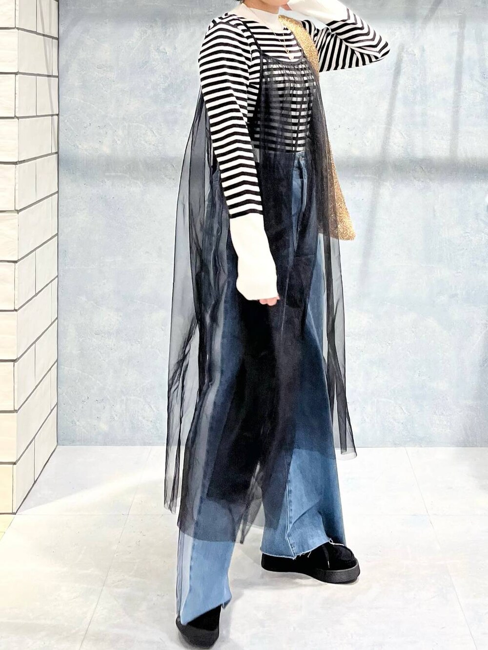 ブラウン系のブルゾン、ブラック系のモカシン/デッキシューズ、ゴールド系のショルダーバッグを着用したレディースの冬コーディネートの5枚目の写真