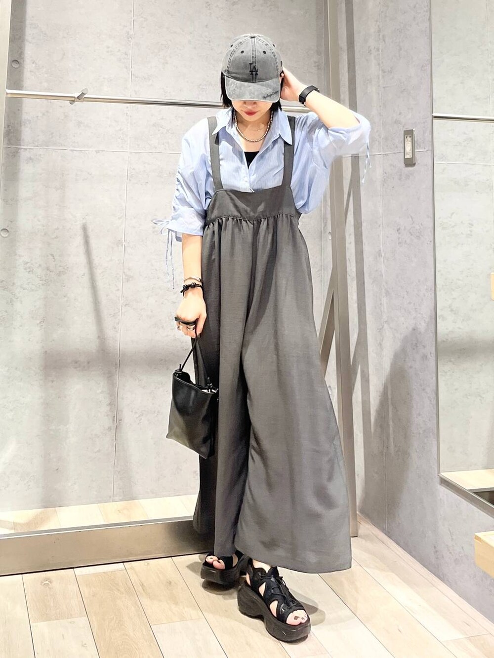 グレー系のサロペット/オーバーオール、ブラック系のサンダル、ブラック系のショルダーバッグを着用したレディースの夏コーディネートの3枚目の写真