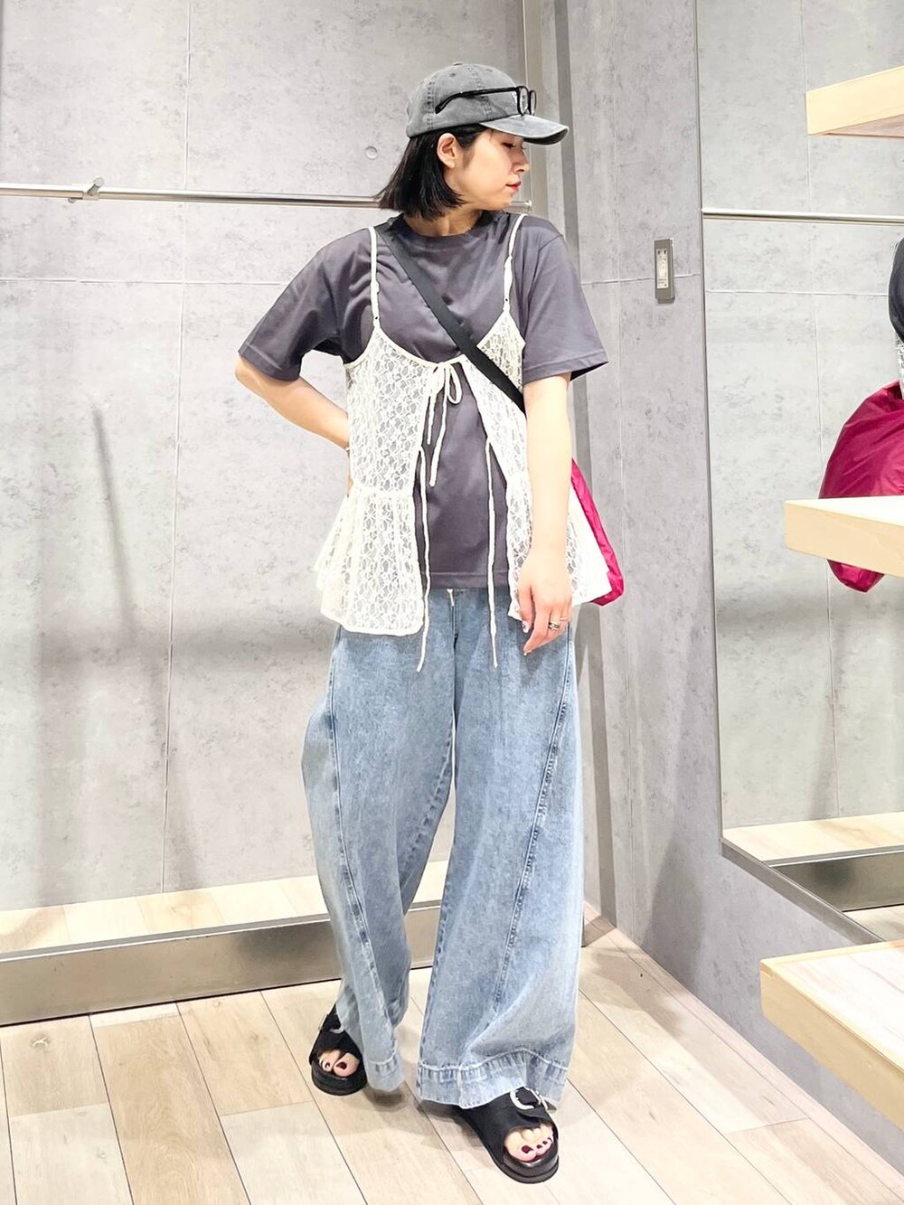 ブルー系のデニムパンツ、ブラック系のサンダル、ピンク系のショルダーバッグを着用したレディースの夏コーディネートの2枚目の写真