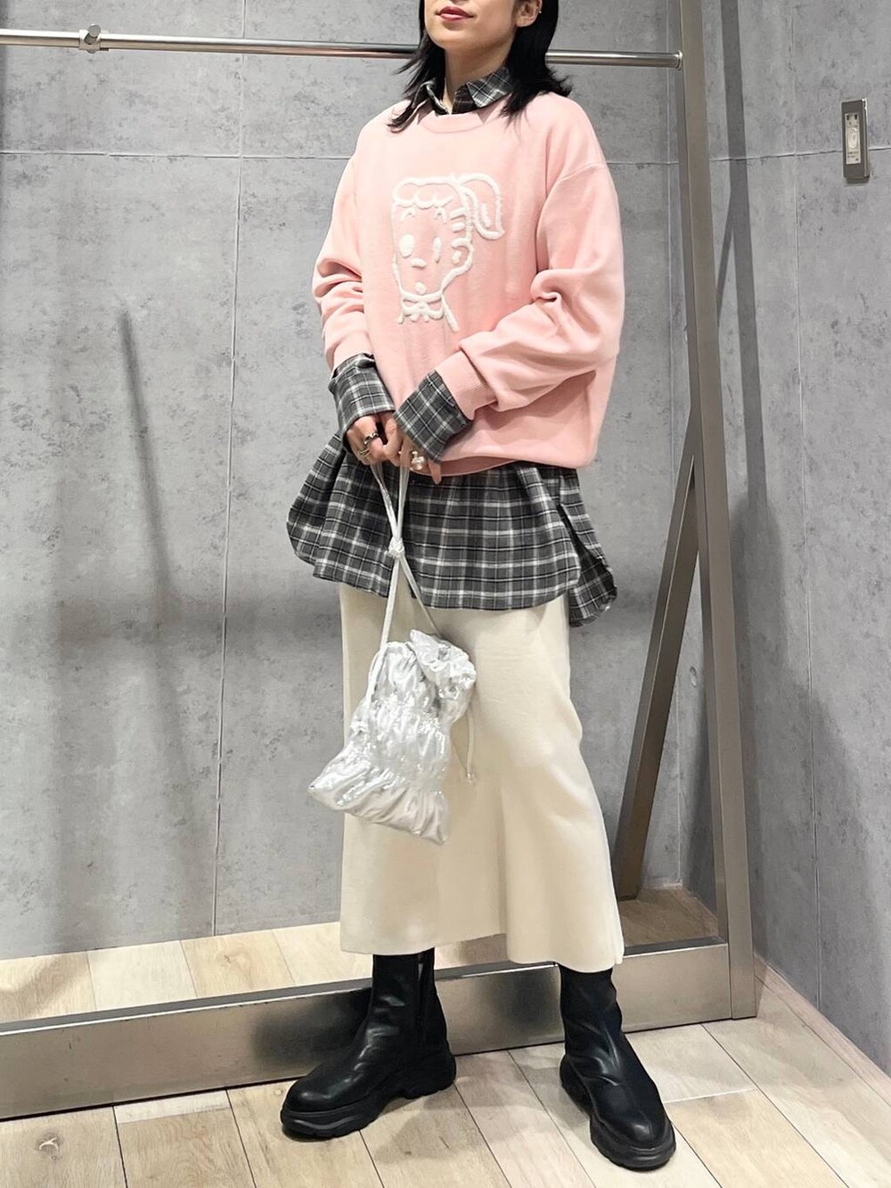 シルバー系のショルダーバッグ、ホワイト系のスカート、ブラック系のブーツを着用したレディースの冬コーディネートの4枚目の写真