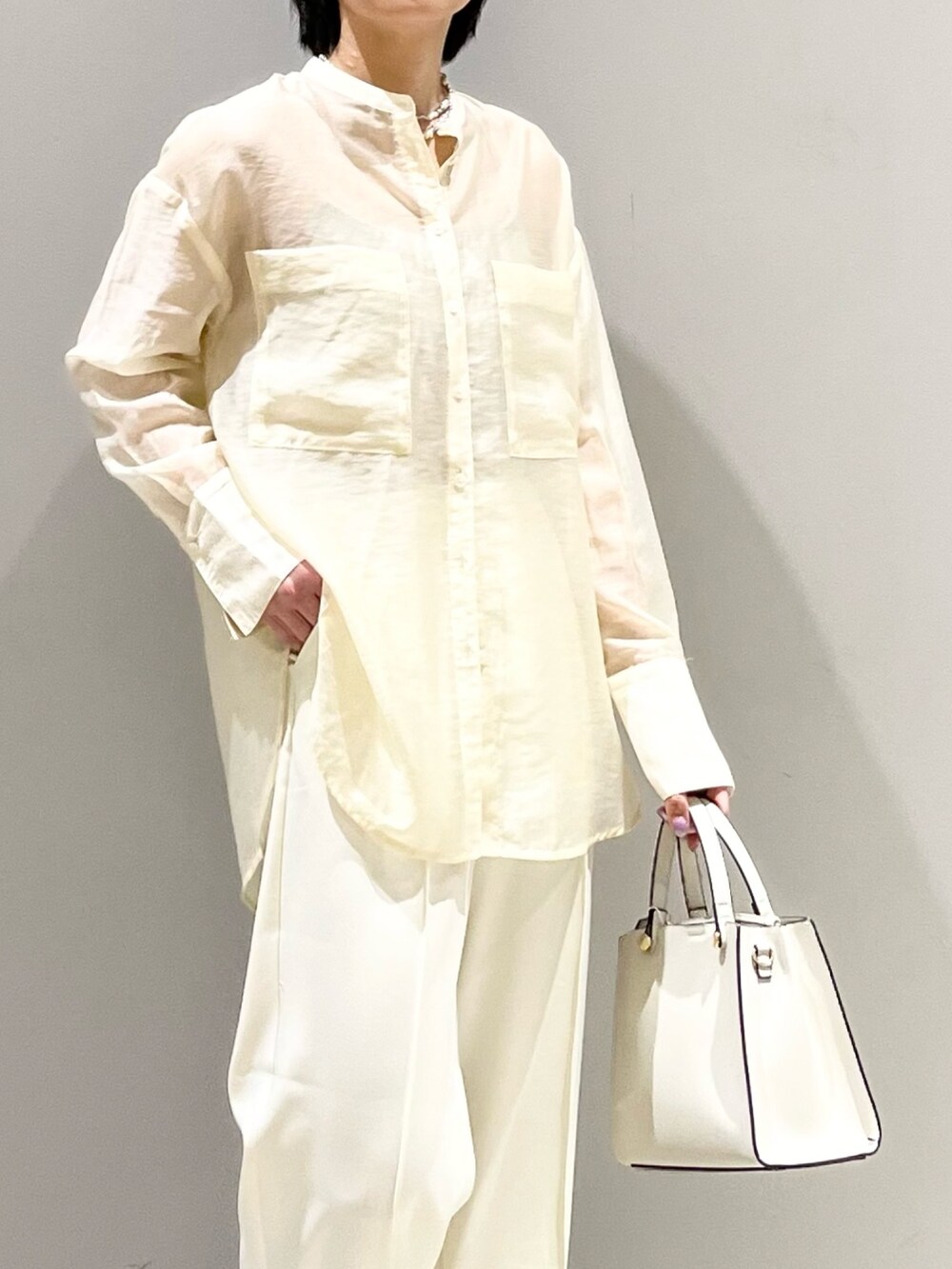 ホワイト系のシャツ/ブラウス、ホワイト系のスラックス、ホワイト系のショルダーバッグを着用したレディースの夏コーディネートの7枚目の写真