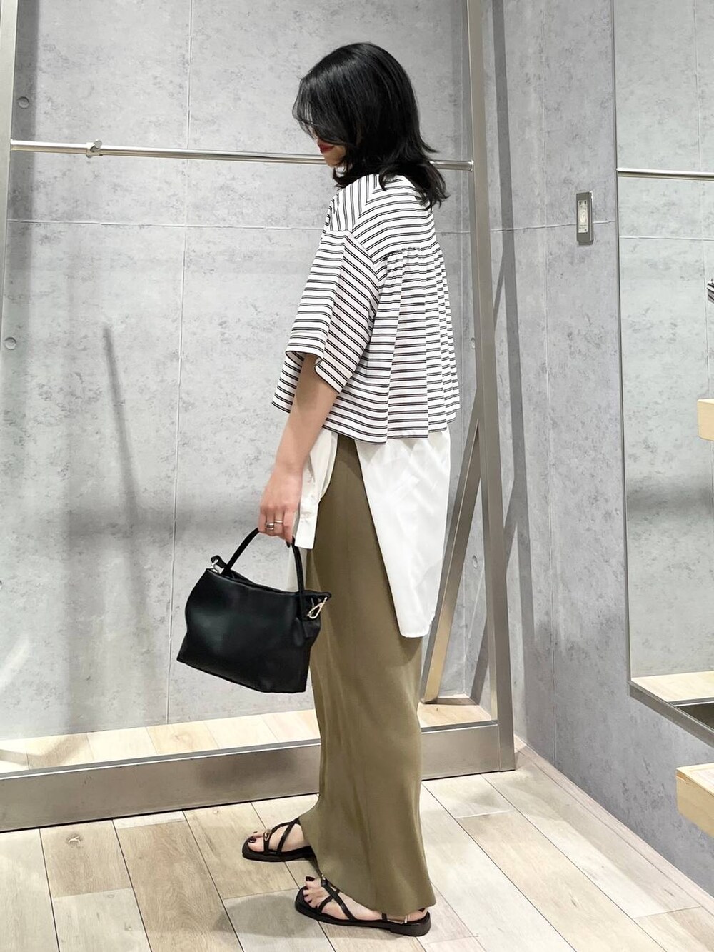 グリーン系のスカート、ホワイト系のTシャツ/カットソー、ホワイト系のシャツ/ブラウスを着用したレディースの春コーディネートの5枚目の写真