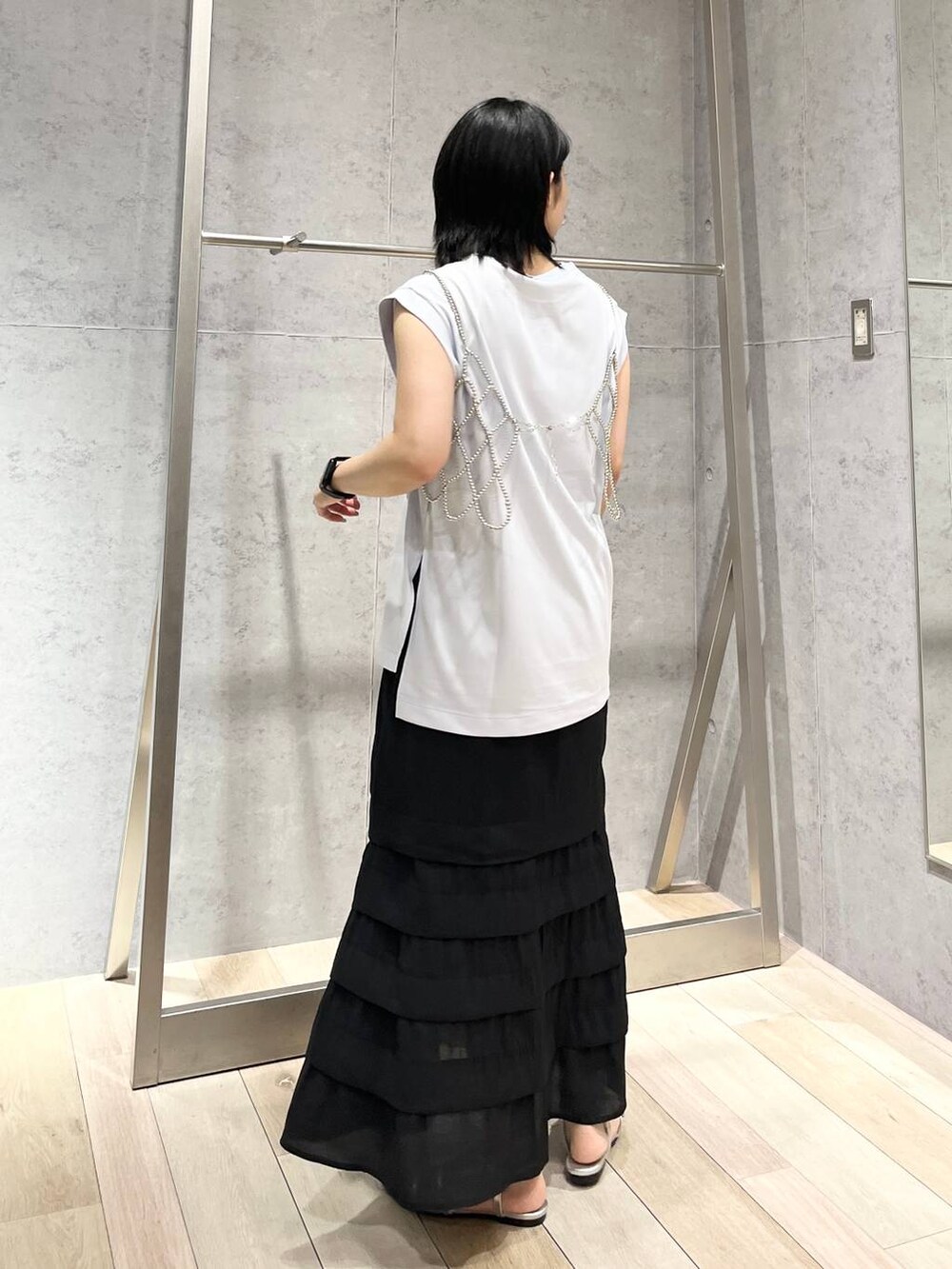 シルバー系のショルダーバッグ、ブルー系のTシャツ/カットソー、シルバー系のサンダルを着用したレディースの夏コーディネートの3枚目の写真