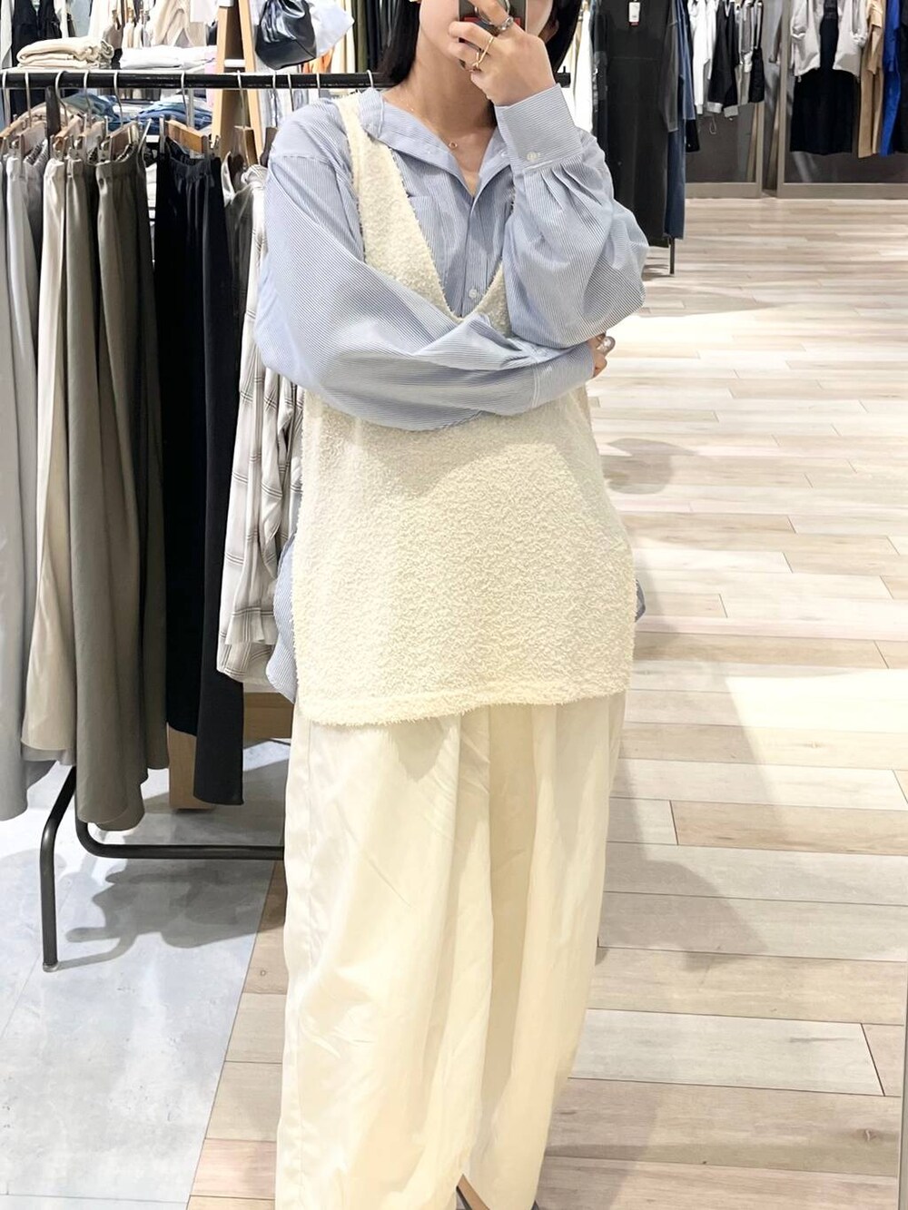 ブラック系のショルダーバッグ、ブラック系のパンプス、ブルー系のシャツ/ブラウスを着用したレディースの春コーディネートの2枚目の写真