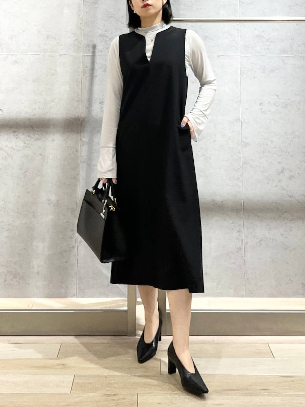 ブラック系のパンプス、グレー系のTシャツ/カットソー、ブラック系のショルダーバッグを着用したレディースの冬コーディネートの7枚目の写真