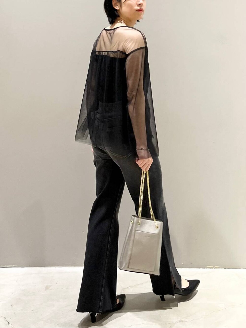 ブラック系のチューブトップ、ブラック系のTシャツ/カットソー、ブラック系のデニムパンツを着用したレディースの秋コーディネートの4枚目の写真