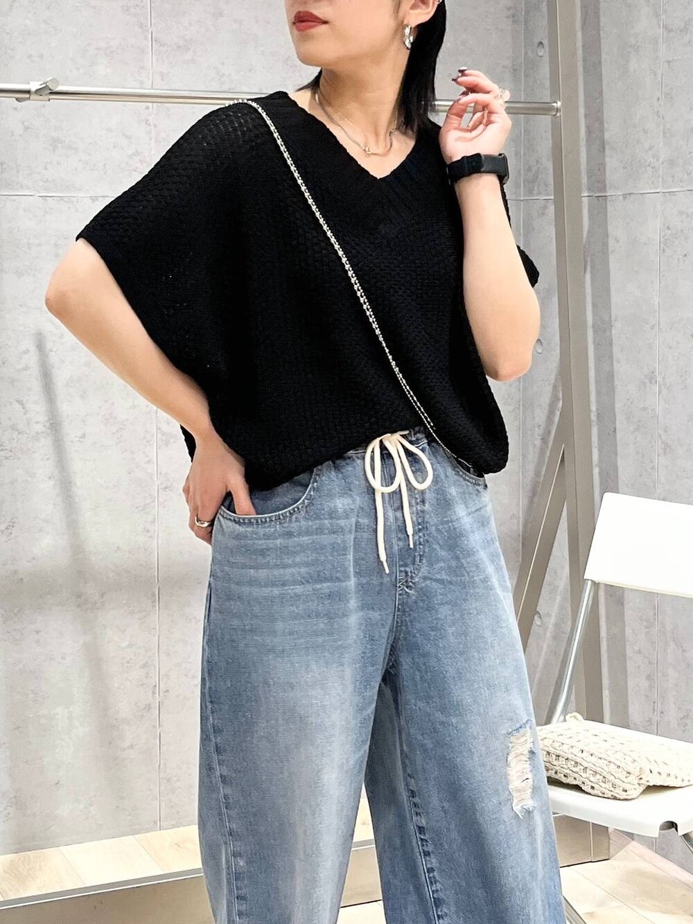 シルバー系のサンダル、ブラック系のニット/セーター、ブルー系のデニムパンツを着用したレディースの春コーディネートの3枚目の写真