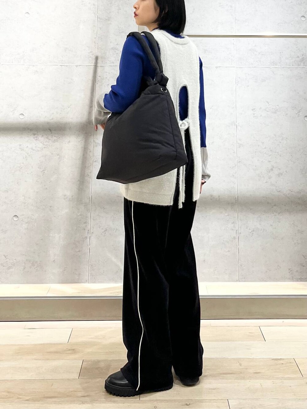 ブラック系のブーツ、ブルー系のニット/セーター、ブラック系のその他パンツを着用したレディースの冬コーディネートの5枚目の写真