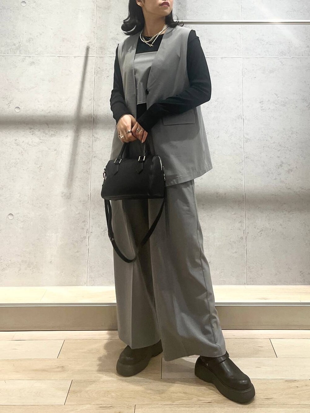 ブラック系のボストンバッグ、グレー系のその他パンツ、ブラック系のサンダルを着用したレディースの春コーディネートの6枚目の写真