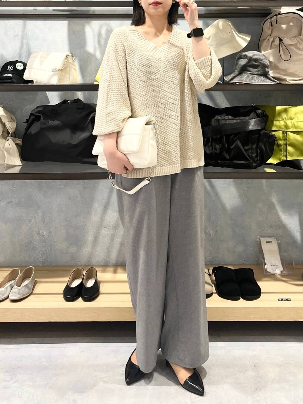 ホワイト系のショルダーバッグ、ホワイト系のニット/セーター、グレー系のスラックスを着用したレディースの春コーディネートの9枚目の写真
