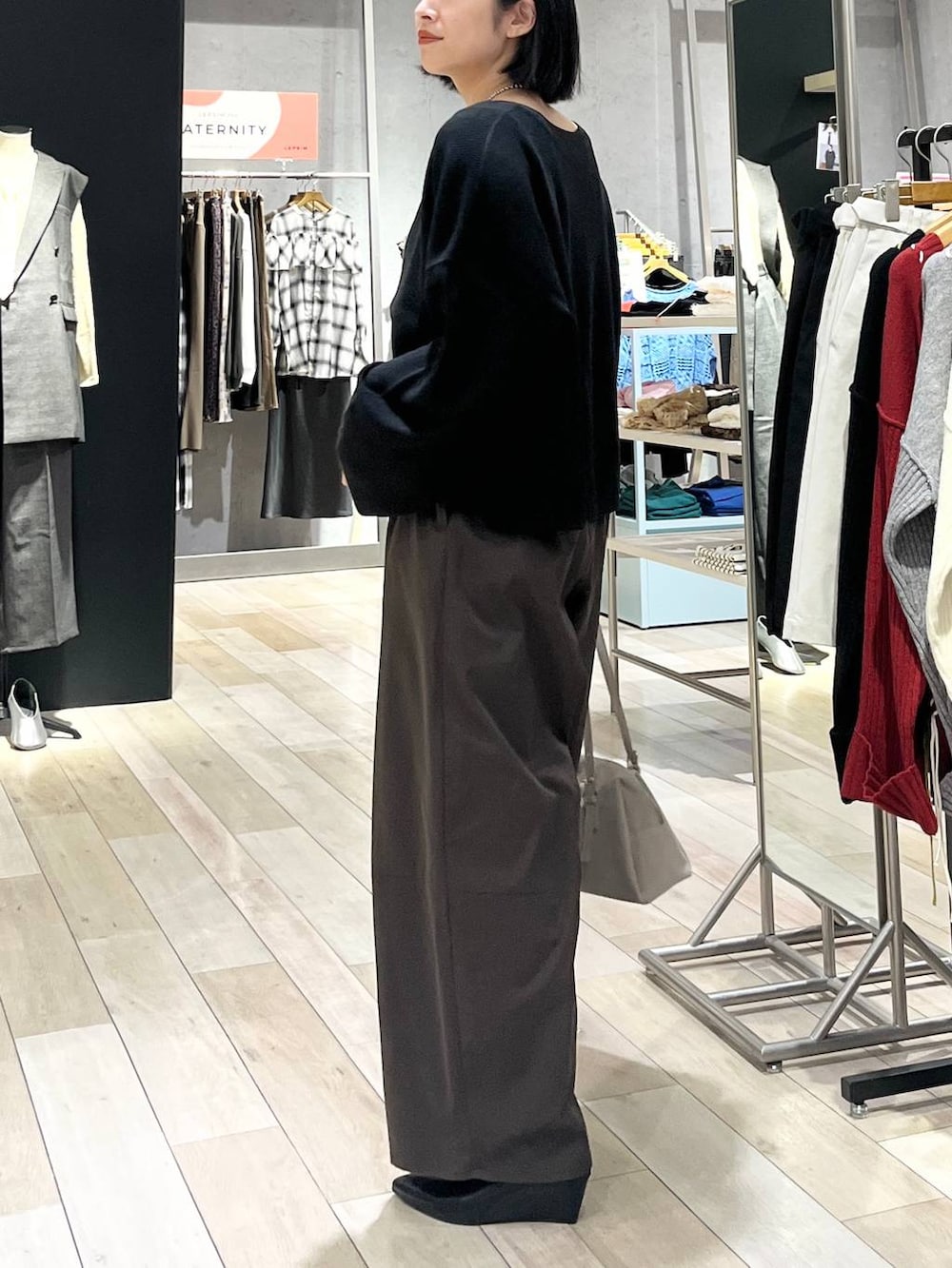 ブラック系のニット/セーター、ブラウン系のその他パンツ、ベージュ系のボストンバッグを着用したレディースの秋コーディネートの4枚目の写真