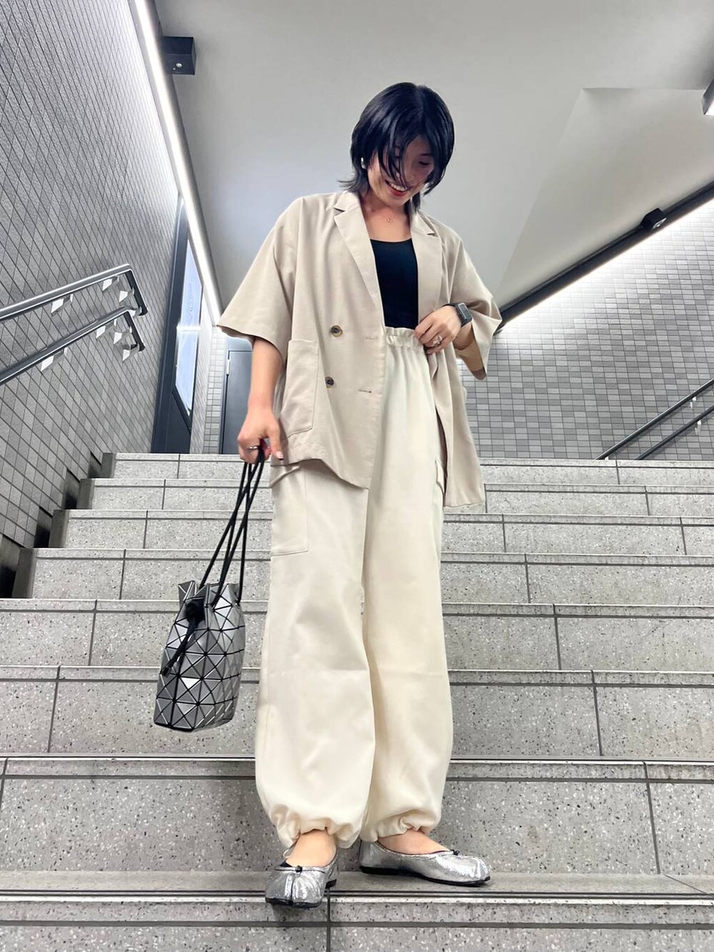 ホワイト系のカーゴパンツ、ベージュ系のテーラードジャケットを着用したレディースの春コーディネートの2枚目の写真