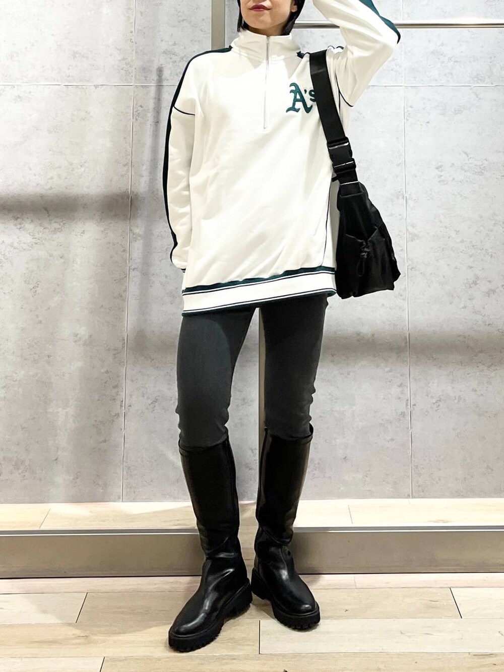 ホワイト系のTシャツ/カットソー、ブラック系のブーツ、グレー系のデニムパンツを着用したレディースの冬コーディネートの9枚目の写真