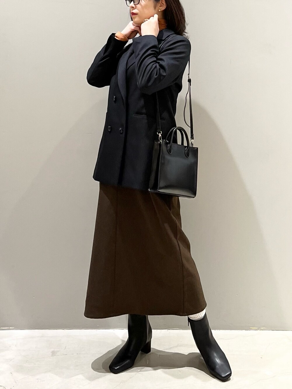 ブラウン系のワンピース、ブラック系のブーツ、ブラウン系のジャケット/アウターを着用したレディースの冬コーディネートの2枚目の写真