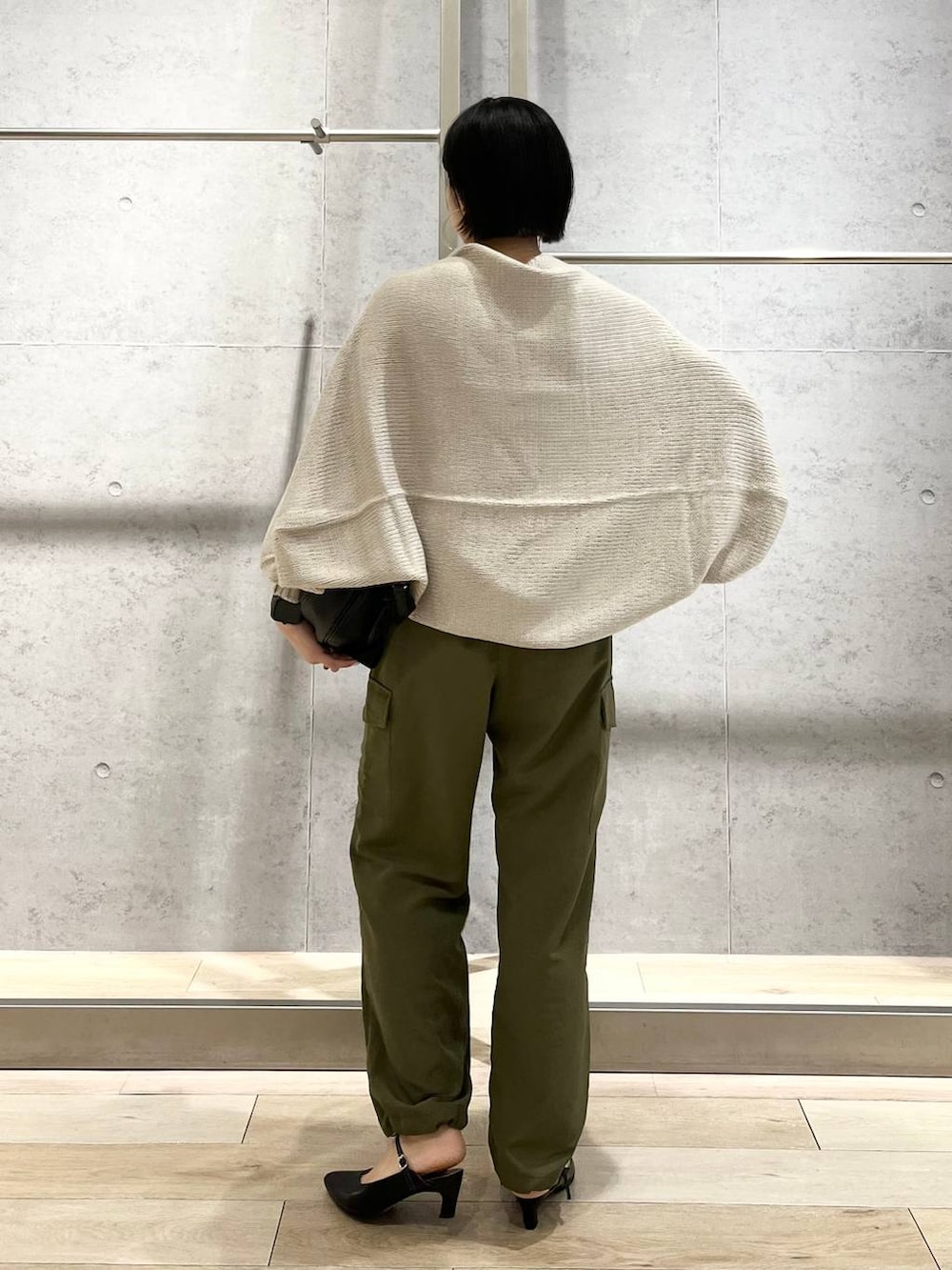 ホワイト系のキャミソール、ベージュ系のカーディガン/ボレロ、グリーン系のカーゴパンツを着用したレディースの秋コーディネートの3枚目の写真