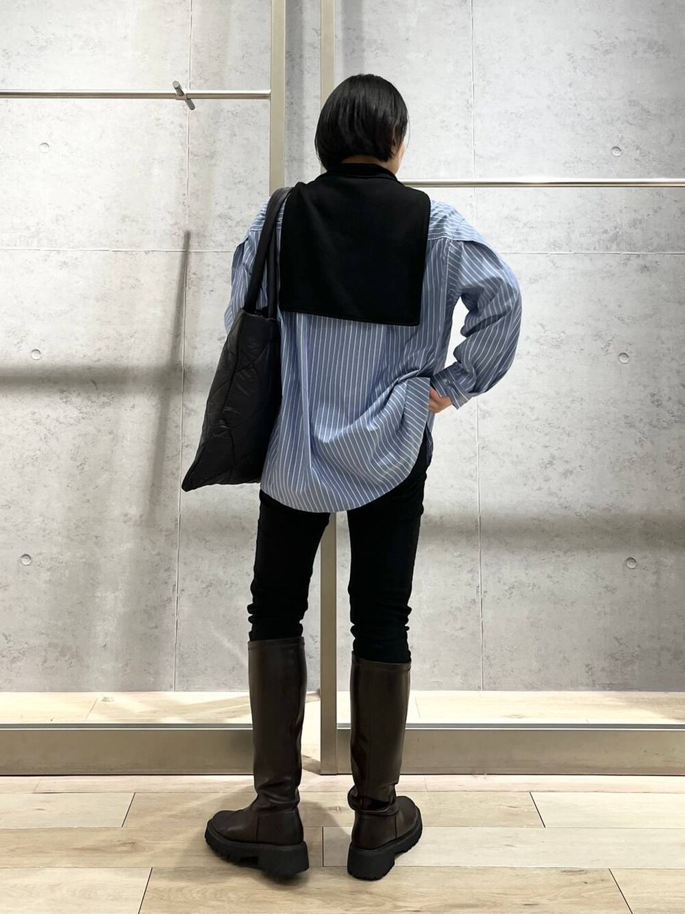 ブラウン系のブーツ、ブラック系のその他パンツ、ブルー系のシャツ/ブラウスを着用したレディースの秋コーディネートの6枚目の写真