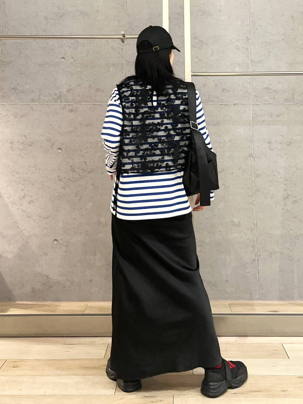 ブラック系のスカート、ブルー系のTシャツ/カットソー、ブラック系のスニーカーを着用したレディースの冬コーディネートの5枚目の写真