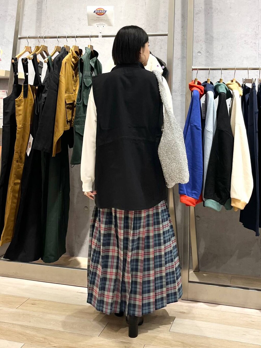 ブラック系のベスト、ホワイト系のスウェット、ブラック系のブーツを着用したレディースの秋コーディネートの3枚目の写真