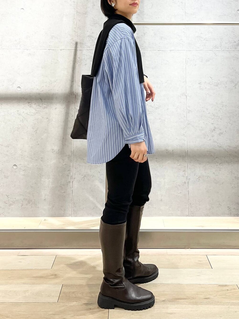 ブラウン系のブーツ、ブラック系のその他パンツ、ブルー系のシャツ/ブラウスを着用したレディースの秋コーディネートの7枚目の写真