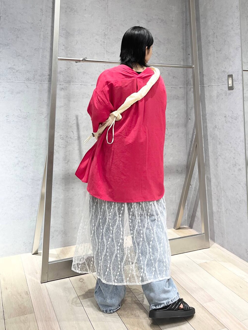 ブラック系のサンダル、ブルー系のデニムパンツ、ホワイト系のスカートを着用したレディースの夏コーディネートの5枚目の写真