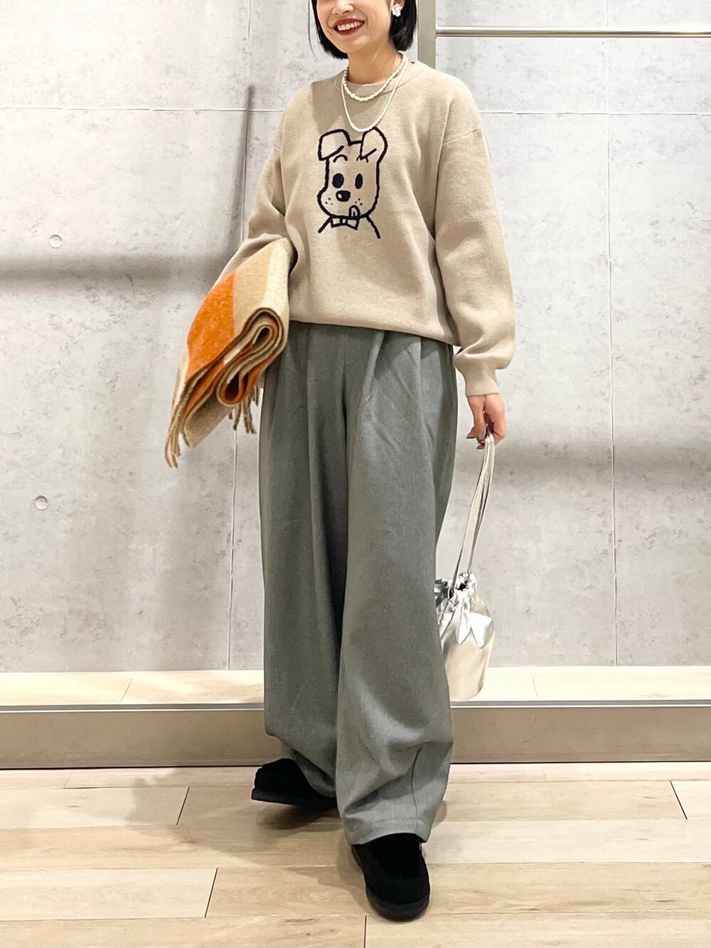 ブラック系のモカシン/デッキシューズ、グレー系のその他パンツ、ベージュ系のニット/セーターを着用したレディースの秋コーディネートの5枚目の写真