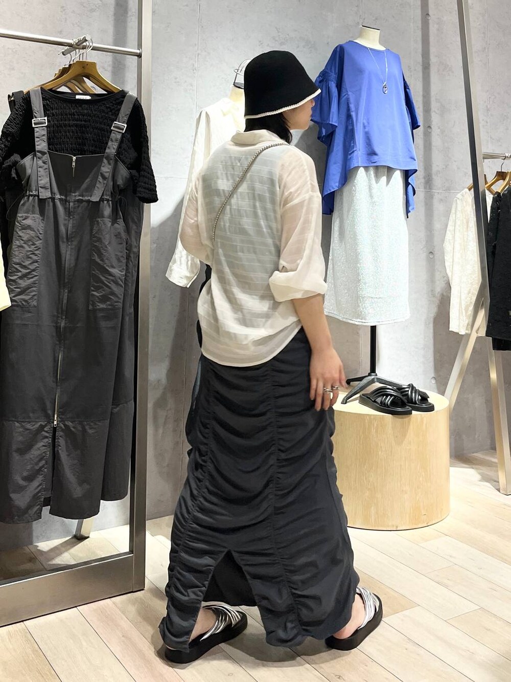 グレー系のスカート、シルバー系のサンダル、ブルー系のタンクトップを着用したレディースの夏コーディネートの6枚目の写真