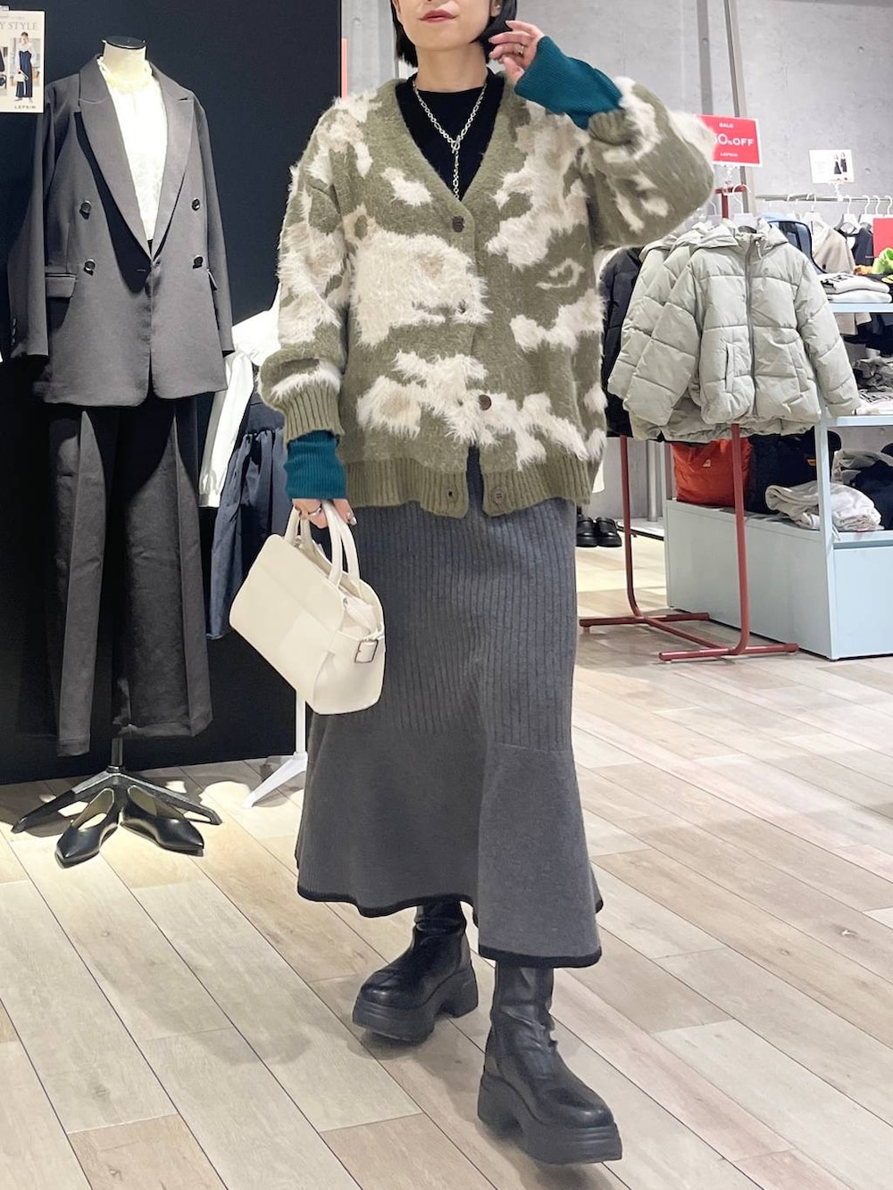 ブラック系のニット/セーター、ブラック系のスカート、ブラック系のブーツを着用したレディースの冬コーディネートの4枚目の写真