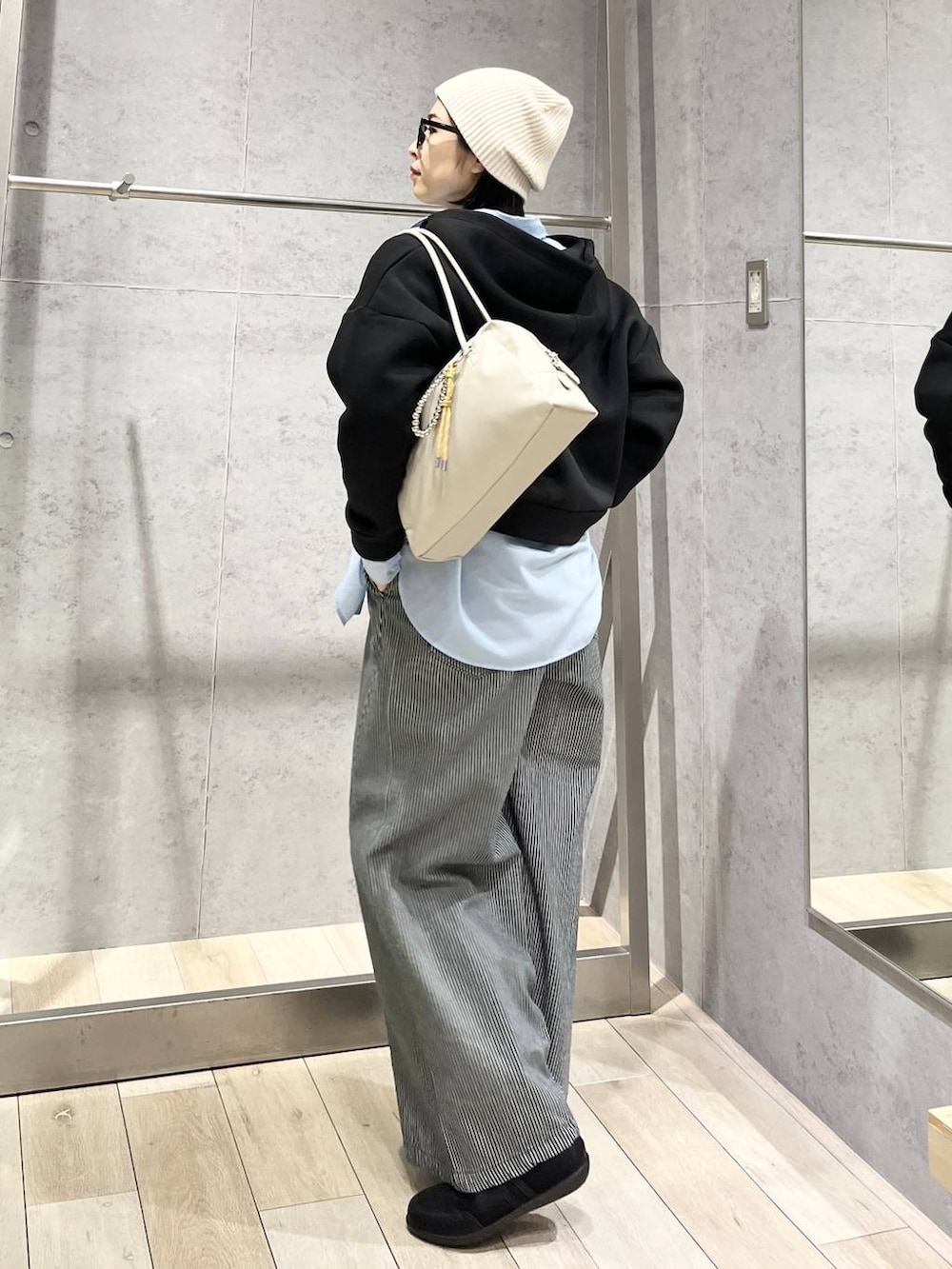 ブルー系のシャツ/ブラウス、ブラック系のボストンバッグ、ブラック系のパンプスを着用したレディースの冬コーディネートの6枚目の写真