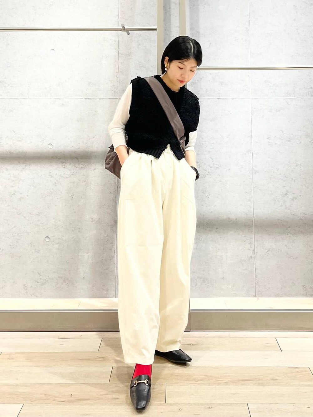 ブラック系のローファー、ホワイト系のTシャツ/カットソー、ブラック系のベストを着用したレディースの秋コーディネートの6枚目の写真