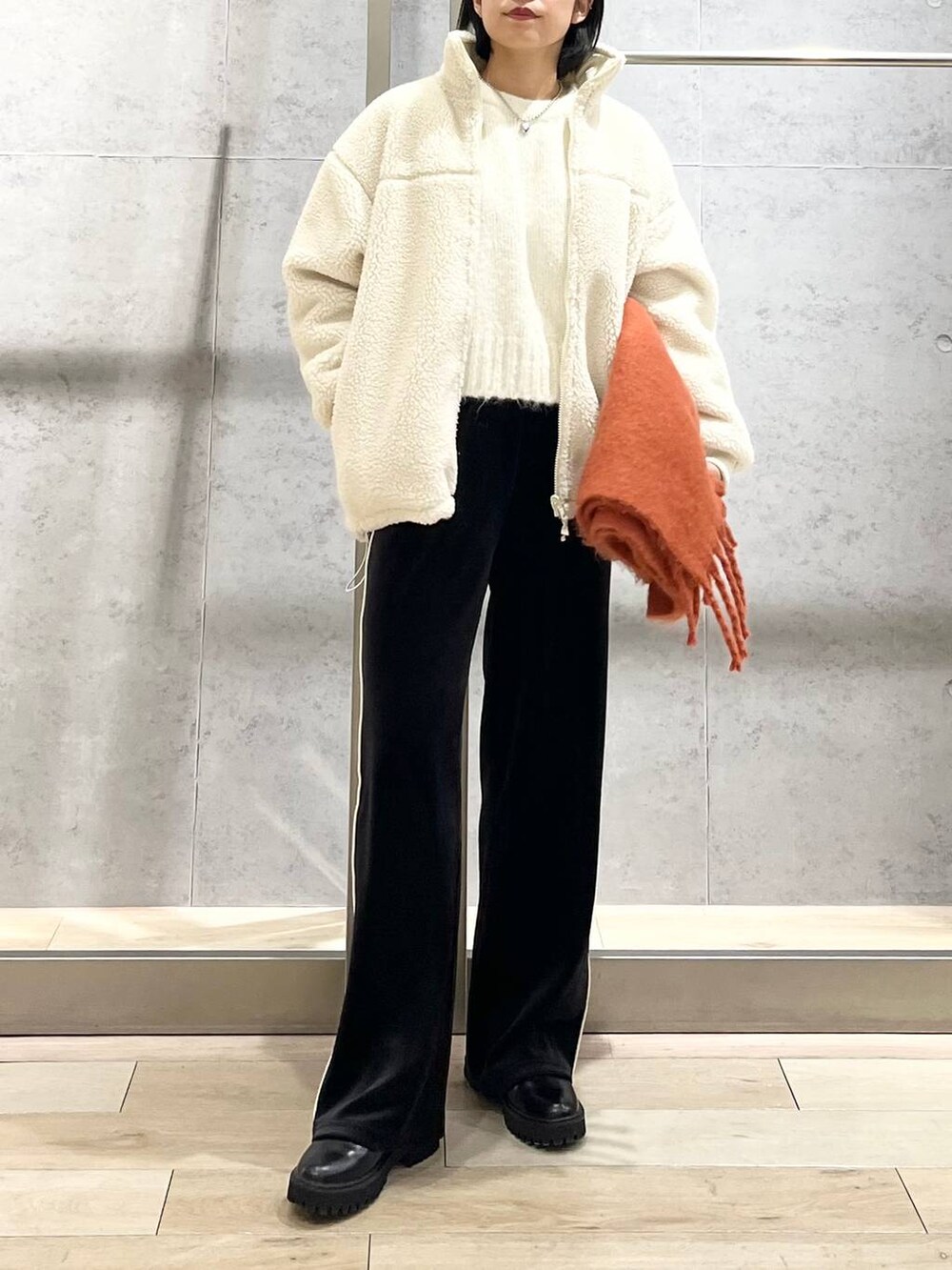 ブラック系のブーツ、ホワイト系のニット/セーター、ホワイト系のその他アウターを着用したレディースの冬コーディネートの8枚目の写真