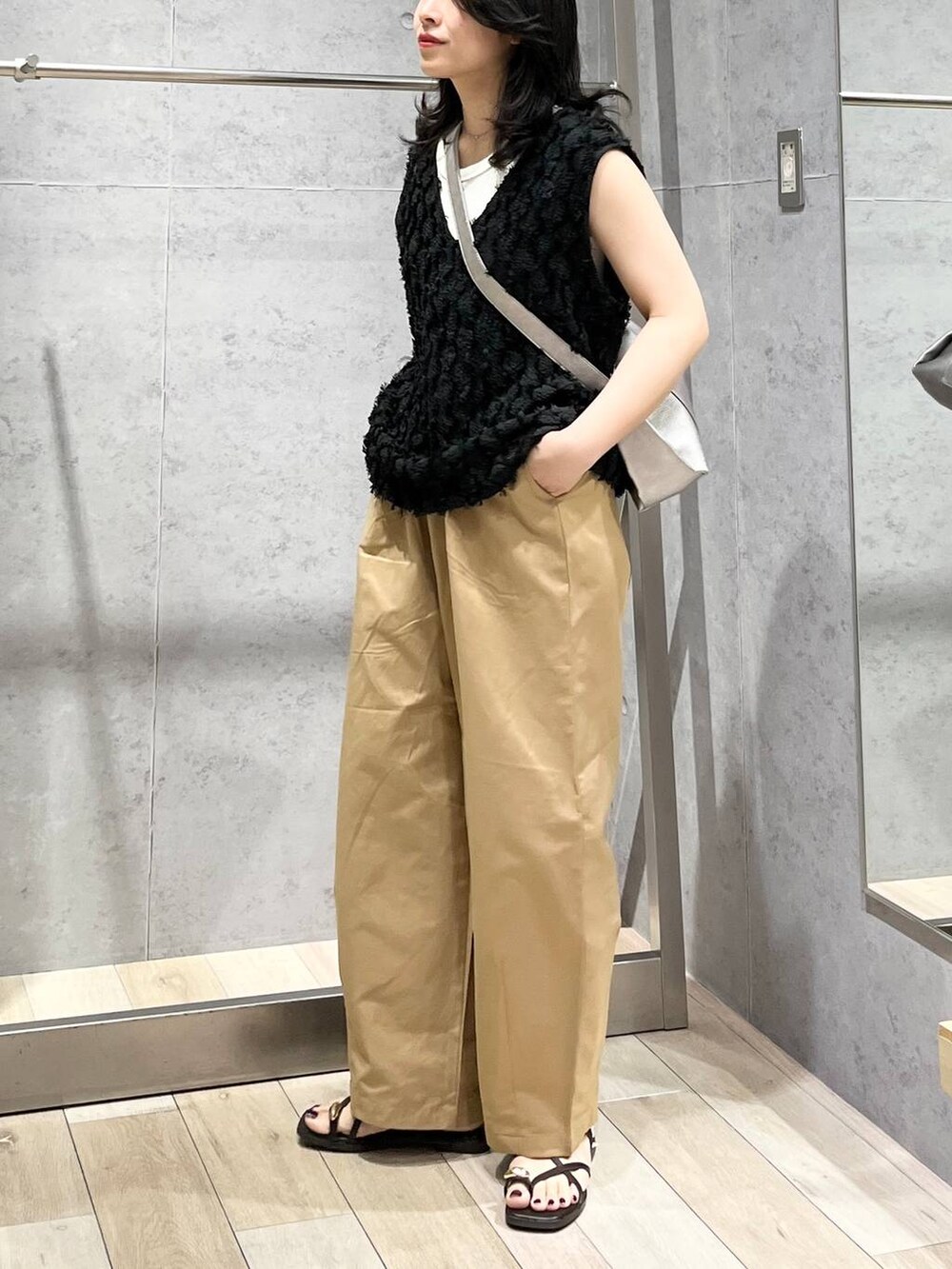 グレー系のショルダーバッグ、ホワイト系のTシャツ/カットソー、ベージュ系のその他パンツを着用したレディースの春コーディネートの4枚目の写真