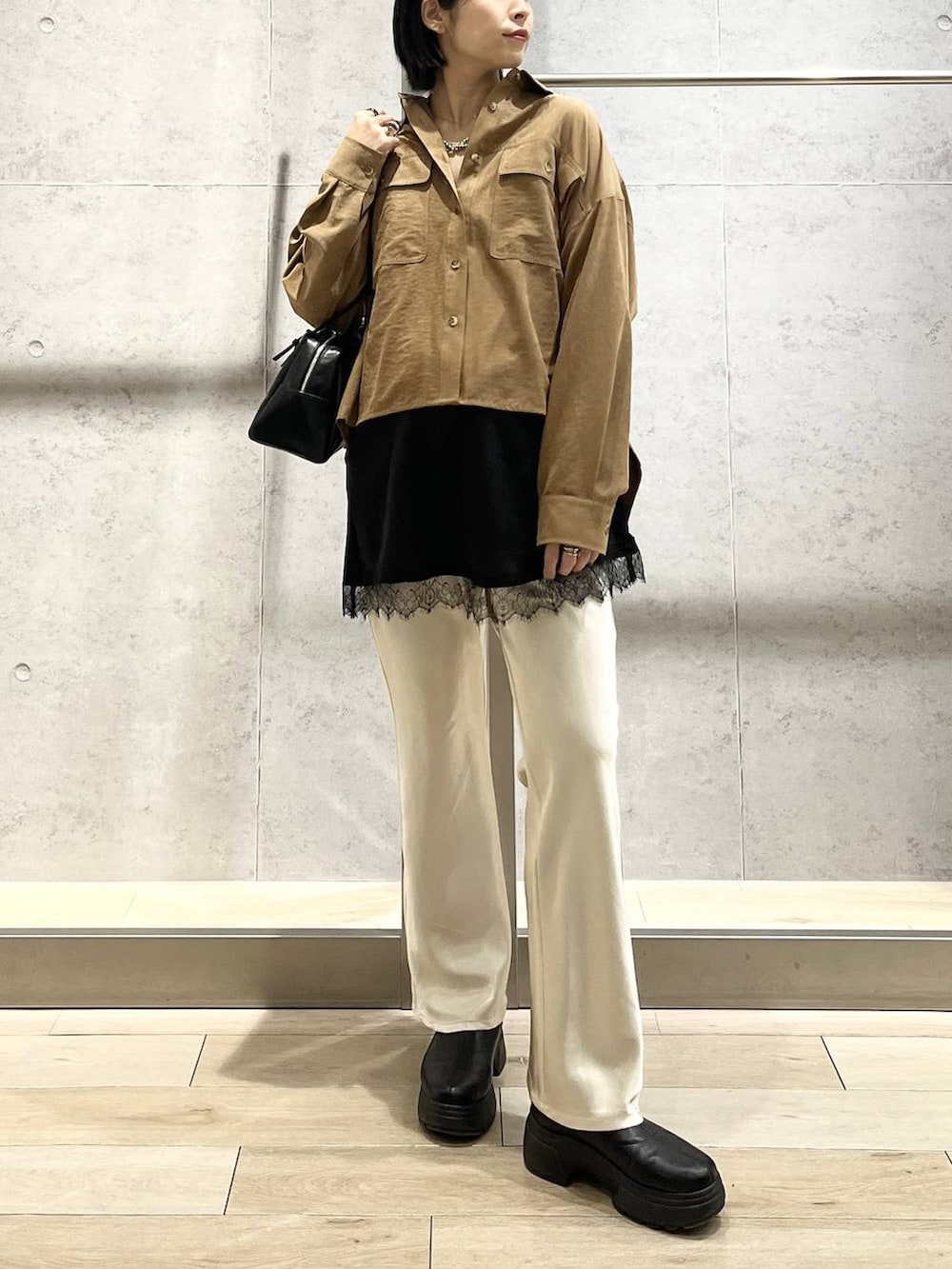 ブラック系のボストンバッグ、ブラック系のブーツ、イエロー系のシャツ/ブラウスを着用したレディースの冬コーディネートの5枚目の写真